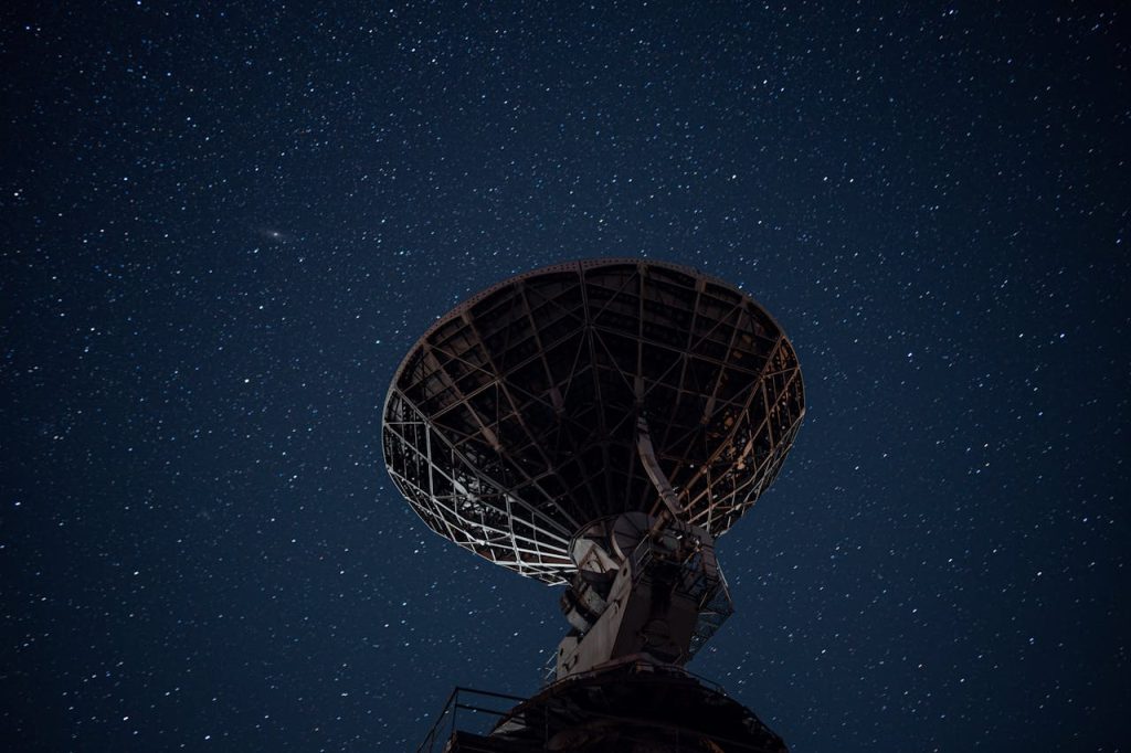radio-telescope-under-bright-starry-sky-6325003 Silhouette of a satellite dish against a starry night sky, capturing cosmic exploration.